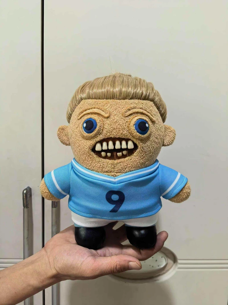 A Weegler football plush held in one hand